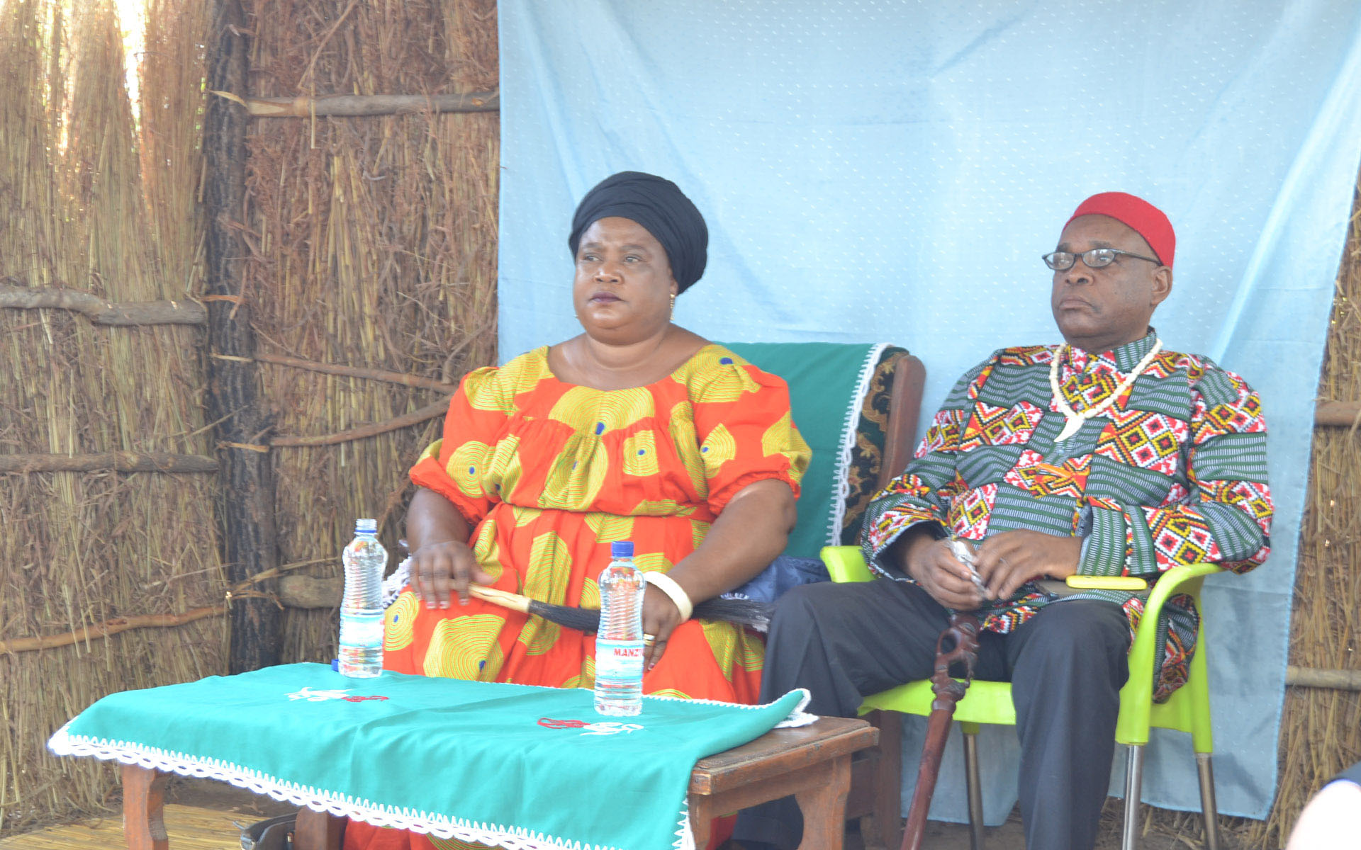 Chieftainess Malembeka, the traditional ruler and landowner, presides over a village meeting, accompanied by her husband.